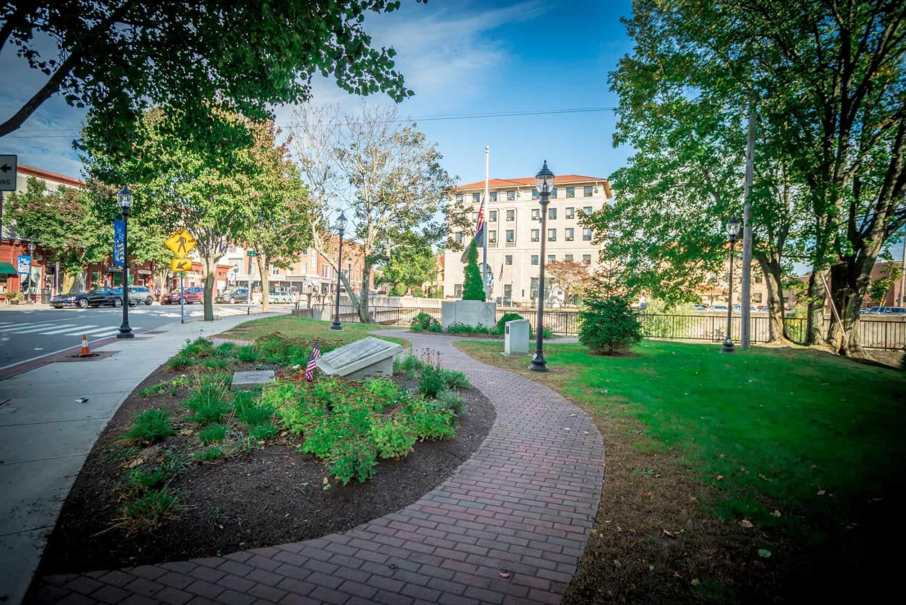 A Park in Westerly Rhode Island with trees and pathways and buildings in the background